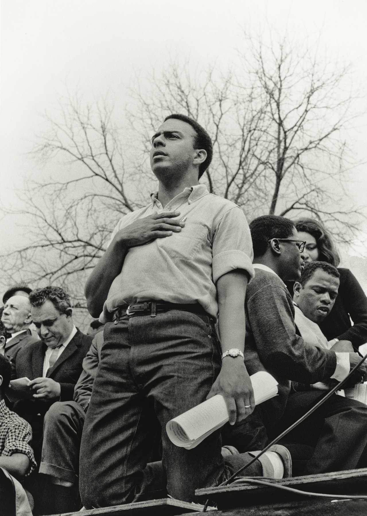 Andrew Young, hand over heart, and on knees, in contemplation, long after the National Anthem was sung, March 25, 1965